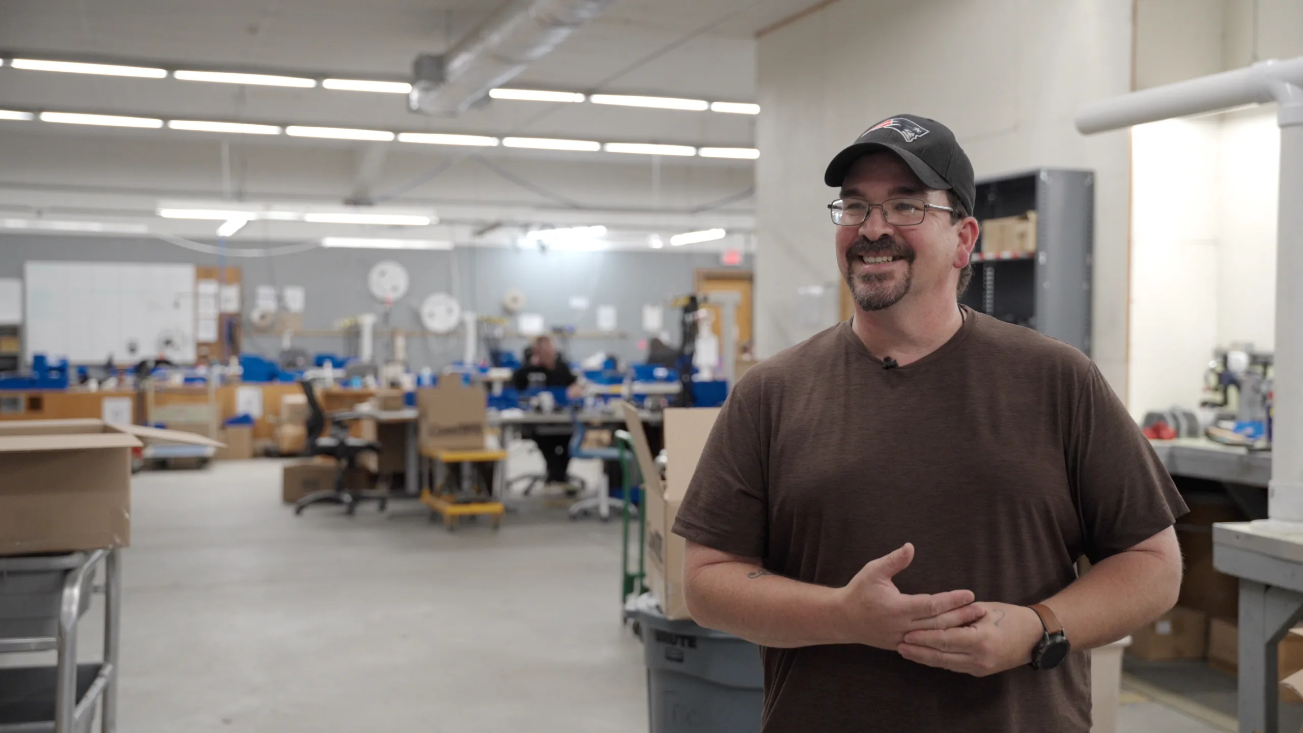 Team member smiling and speaking on the production floor at ConnTrol International Inc. in Putnam, CT.